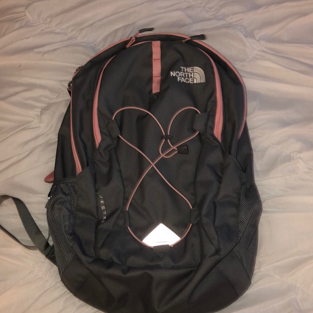 gray and pink north face book bag